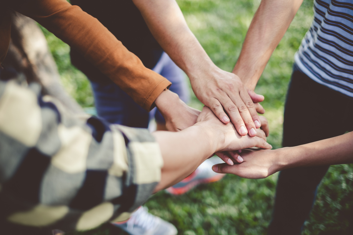 Stacking hands of young teen student, teamwork, togetherness and cooperation concept